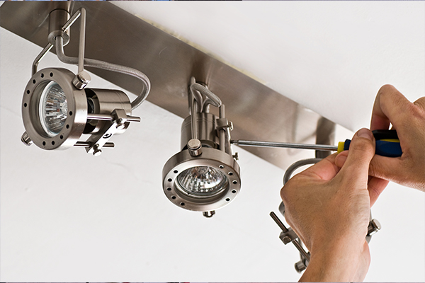 An image of an electrician installing some bathroom lights